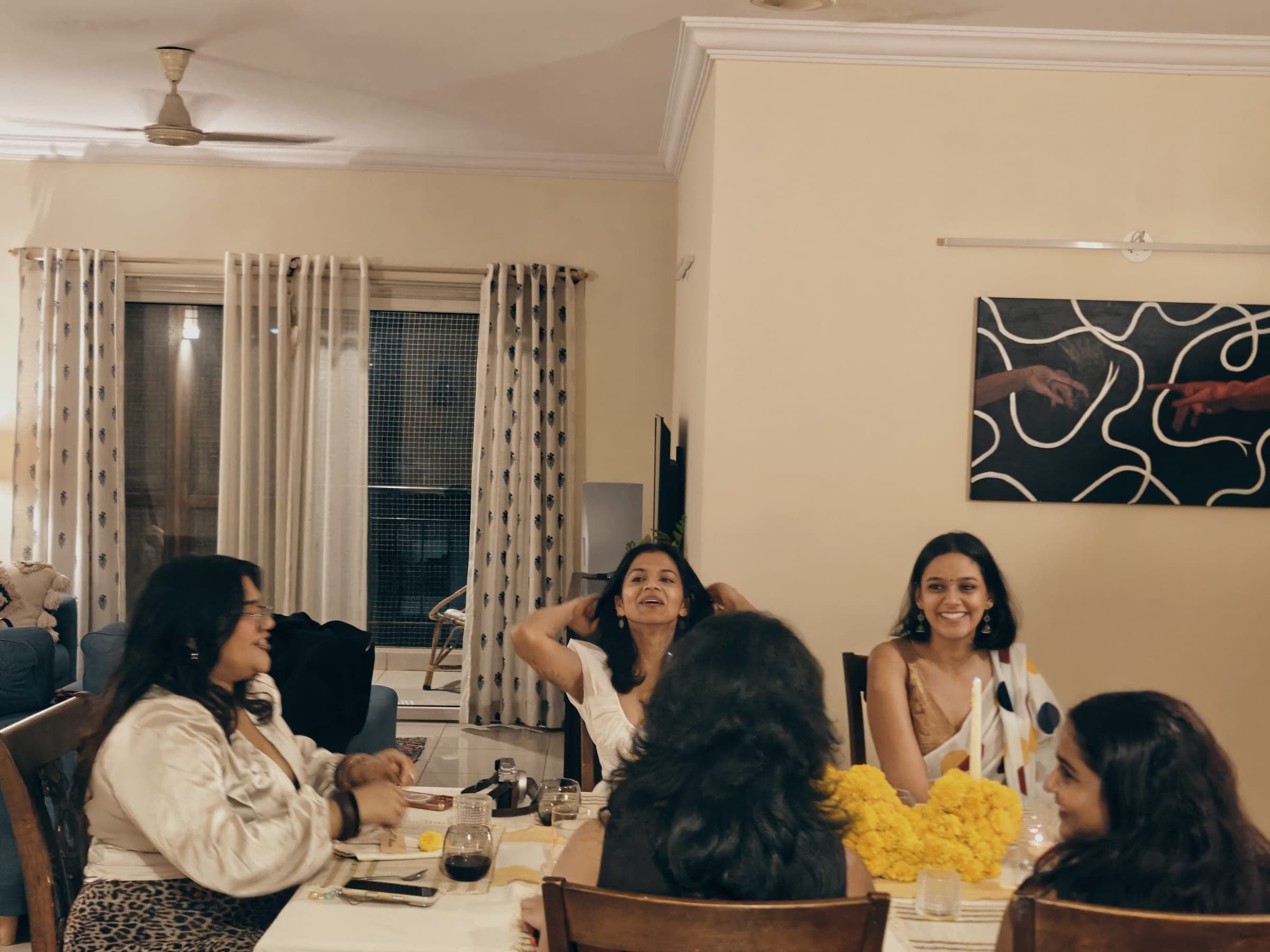 Guests laughing around the table over dinner